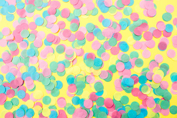 Multicolored confetti on a yellow background. Festive concept