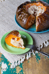 Rice porridge with dried fruits and spices in a pumpkin on a plate on the old wooden table with linen napkin