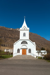 Fototapeta na wymiar White church in a small village in the fjords of Iceland