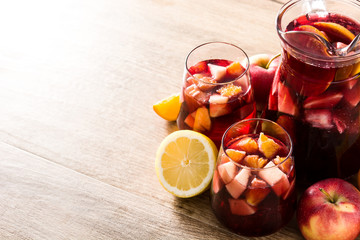 Red wine sangria in glasses on wooden table. Copyspace