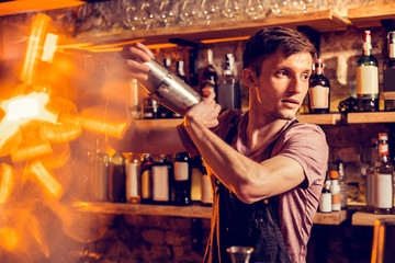Young but experienced barman making cocktail for client - obrazy, fototapety, plakaty