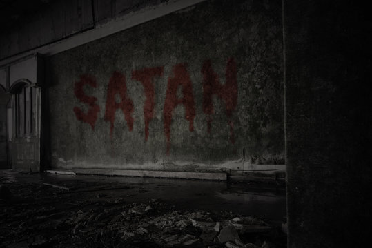 text satan on the dirty wall in an abandoned ruined house