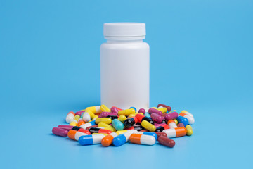 Medicine green, yellow and pink pills or capsules and white bottle