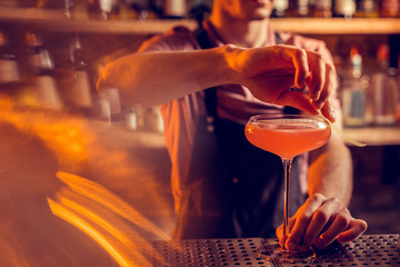 Close up of barman finishing making cocktail for client