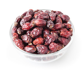 Dried wild rose berries in glass bowl isolated on white background with clipping path