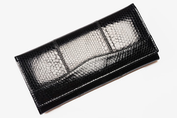 Black purse from skin of a snake on a white background. Close up.