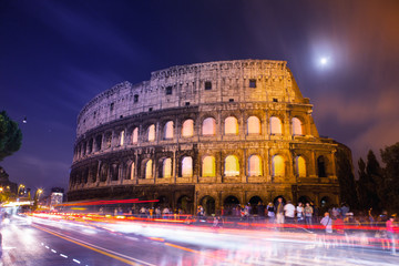 Il Colosseo di notte con la luna piena in lunga esposizione con scie ed effetto fantasma
