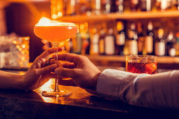 Close of man bringing nice cocktail for his girlfriend