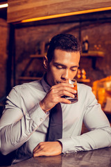 Handsome businessman drinking whisky in the bar