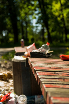 Garbage bins at the benches in the city park. scattered trash