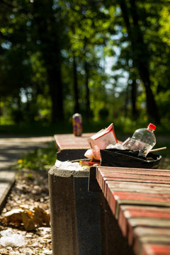 Garbage bins at the benches in the city park. scattered trash