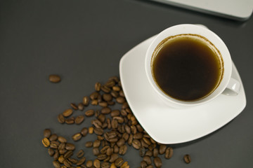 Coffee cup and coffee beans on black background. Top view.