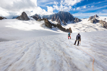 Couple alpinists mountaineers walking glacier  slopes. Mont Blanc.