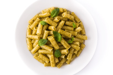 Penne pasta with pesto sauce and basil on a plate isolated on white background. Top view