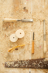 Background of carpenters tools on table in workshop dusted with wood shavings, copy space