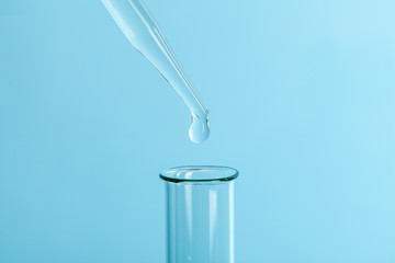 Drop the pipette into the test tube. The study of biological material. Laboratory research. Blue...