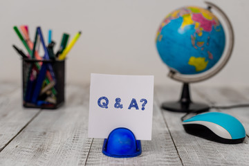 Conceptual hand writing showing Q And A Question. Concept meaning in which demonstrating asks questions and another one answers them Stationary and computer mouse with globe on the wooden desk