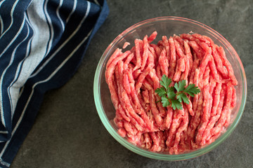 Homemade minced meat over dark slate or stone background