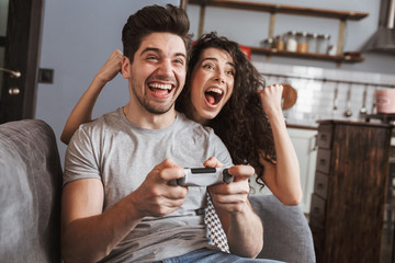 Cheerful young couple relaxing on a couch at home