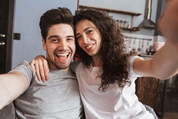 Fototapeta premium Cheerful young couple relaxing on a couch at home