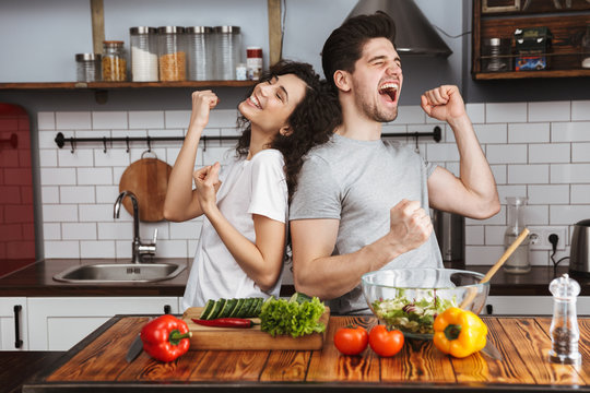 Excited Cheerful Young Couple Cooking Healthy Salad