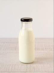 A bottle of fresh milk on a rustic white table