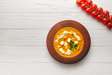 Shahi paneer Indian vegetarian masala gravy meal with vegetables, white sauce and butter paneer cottage cheese spicy food vegan north India dish served with cherry tomatoes on white wooden background