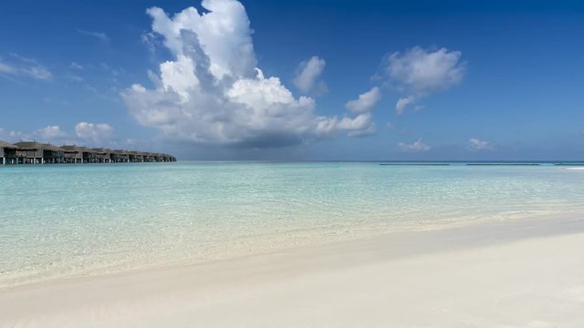 Time lapse of a tropical beach with turquoise sea and approaching clouds of a storm