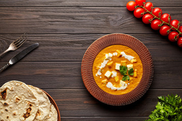 Shahi paneer traditional Indian vegetarian masala gravy meal with vegetables and butter paneer cottage cheese spicy food restaurant style vegan north India dish served with chapati, tomatoes, parsley 