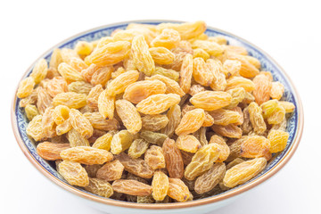 Dried grape or golden raisins in bowl on white background