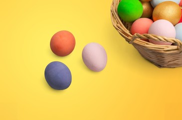 Colorful Easter eggs in basket on yellow background