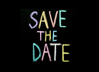 colored text "save the date" on chalkboard