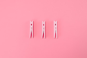 Pink closespins lie on pastel blue background. Minimal summer concept.