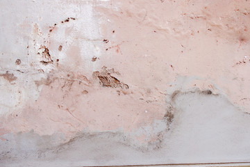 Old weathered painted wall background texture. White dirty peeled plaster wall with falling off...