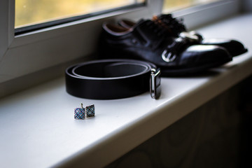 Set of groom accessories on wedding day. Wedding details. Leather men's shoes with belt and bow...