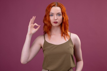 Obraz na płótnie Canvas Caucasian redhead woman with ok sign gesture