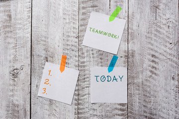 Conceptual hand writing showing Teamwork. Concept meaning combined action of group especially when effective and efficient Plentiful of plain paper sheet attached with wooden textured table