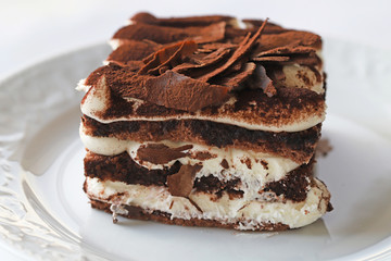 Chocolate pastry with whipped cream on white background