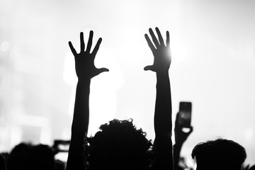 people at a concert with their hands in the air dancing and singing 