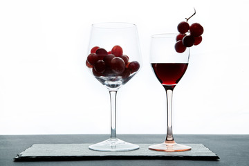  Red grape and wine in crystal glasses on white background