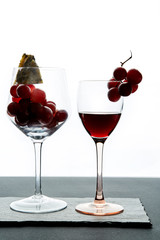 Composition of glasses with ripe grape and red wine served on slate board
