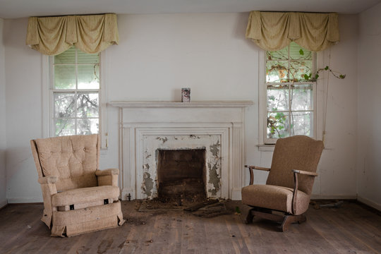 Living Room With Two Chairs With A Fireplace In An Abandoned Home