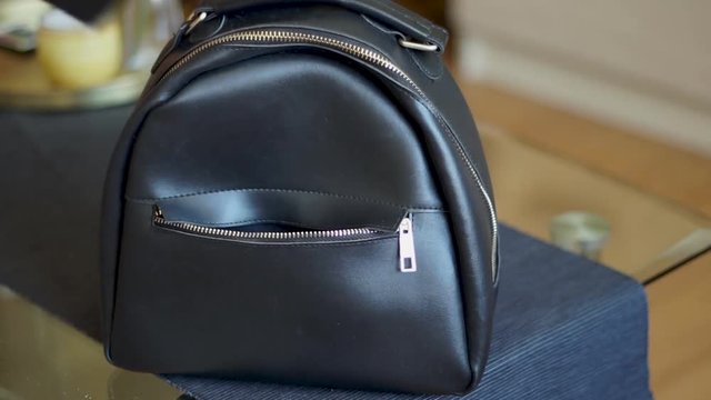 Pickpocket stealing a phone from a small black backpack