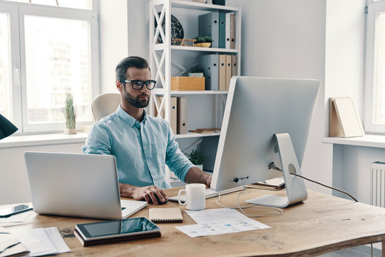 Inspired to work hard. Young modern businessman working using computer while sitting in the office