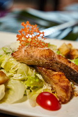 Fried fish warm Caesar salad closeup. Menu presentation closeup photo - image