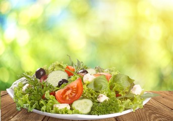 Individual side serving of delicious fresh Greek salad with feta cheese, olives, tomatoes and salad greens