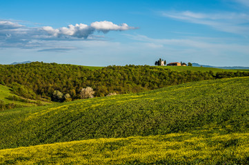 Tuscany spring, rolling hills and windmill on sunset. Rural landscape. Green fields. Italy, Europe