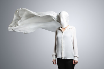 Anonymous model, covered with a white cloth. Woman in white shirt with head wrapped in waving white...