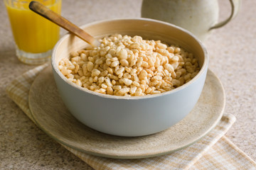 Puffed rice breakfast cereal in a wooden bowl
