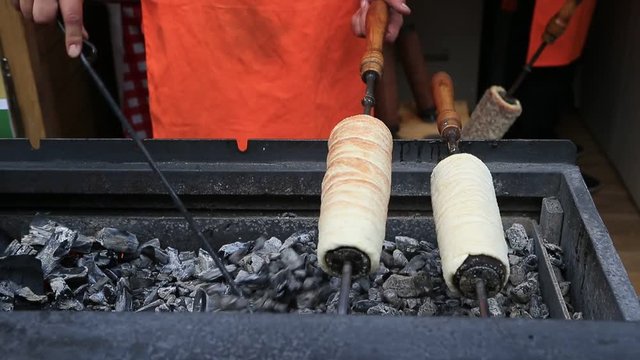 Trdelnik on the charcoal grill being prepared at the street bakery in Budapest, Hungary. Traditional czech sweet treat.